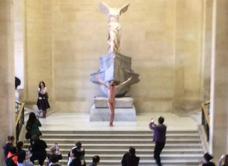 Adrián Pino desnudo ante la Victoria de Samotracia del Louvre