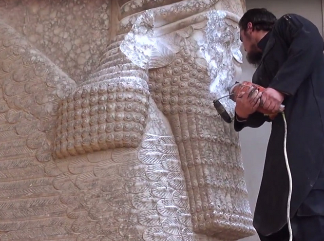 Miembro de ISIS destruyendo una escultura asiria