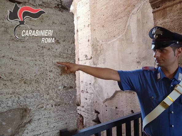 Un policía señala el lugar donde la mujer grabó su nombre el Coliseo