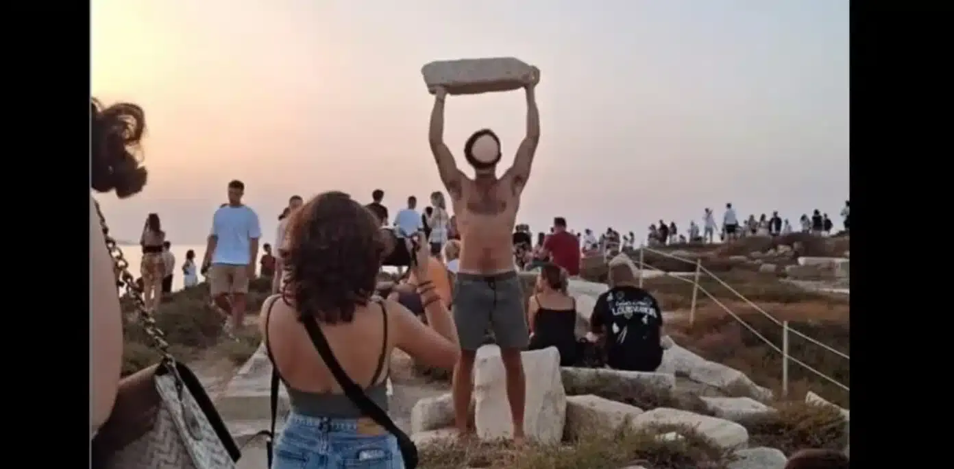 Turista levantando una piedra del templo de Apolo en Naxos